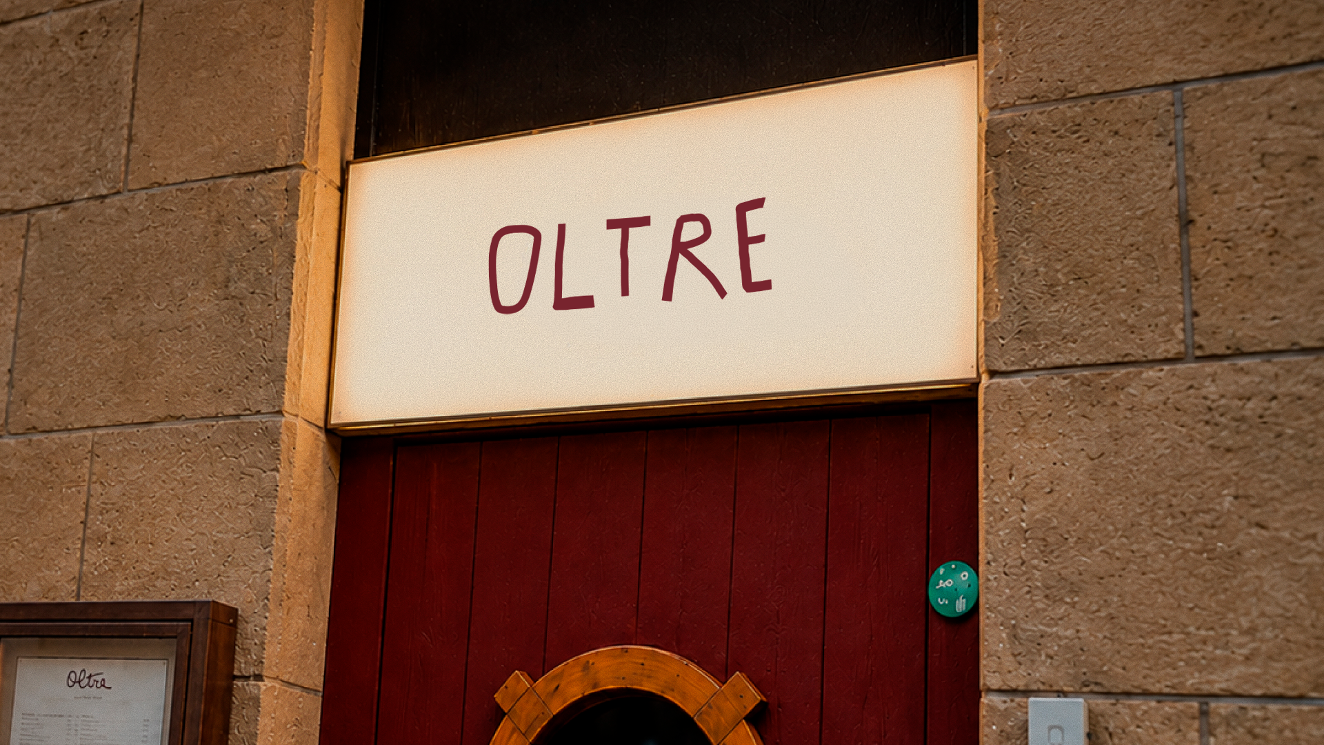 Cartel luminoso de OLTRE en la fachada de piedra del restaurante