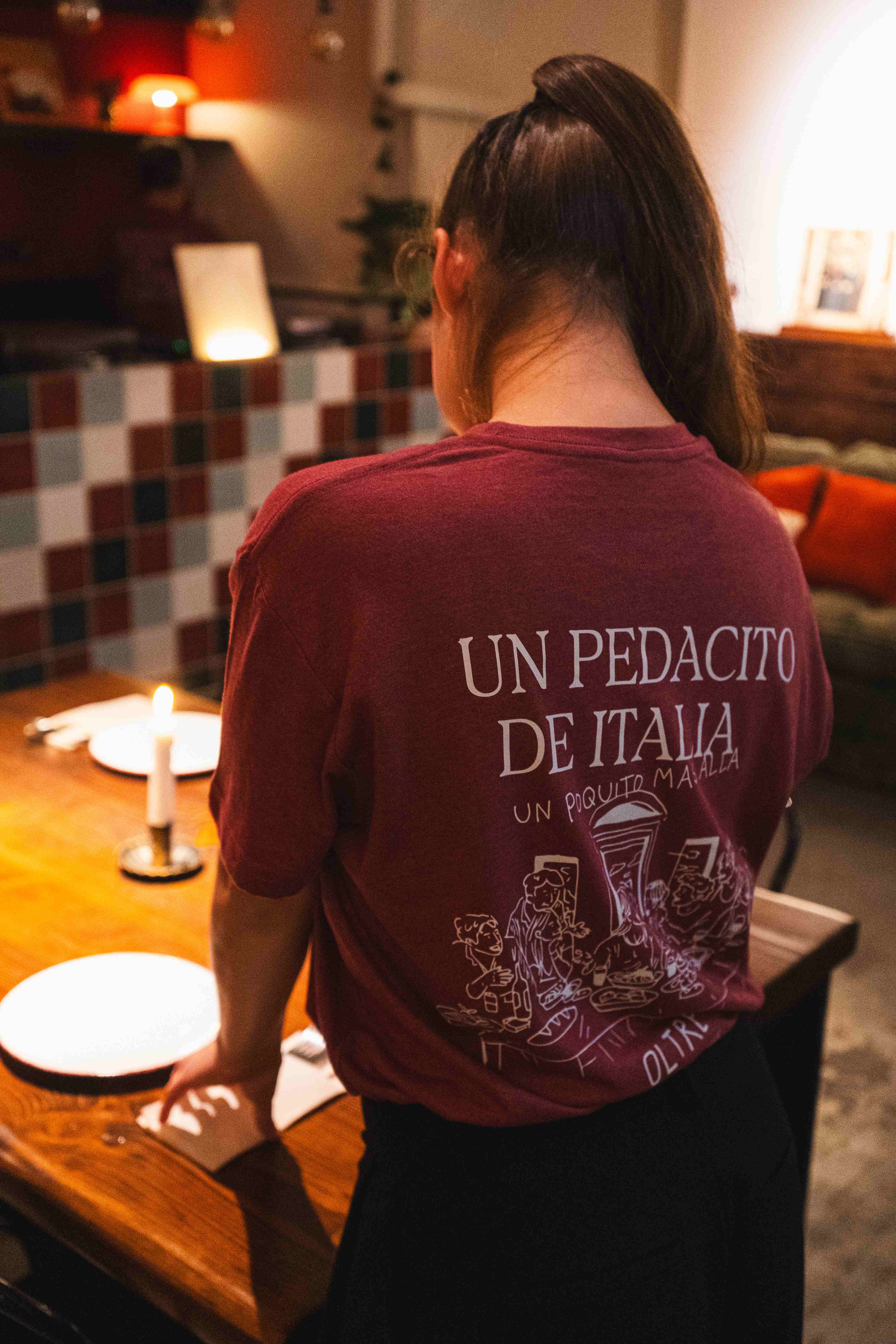 Persona de espaldas con una camiseta de Oltre que lleva el mensaje Un pedacito de Italia