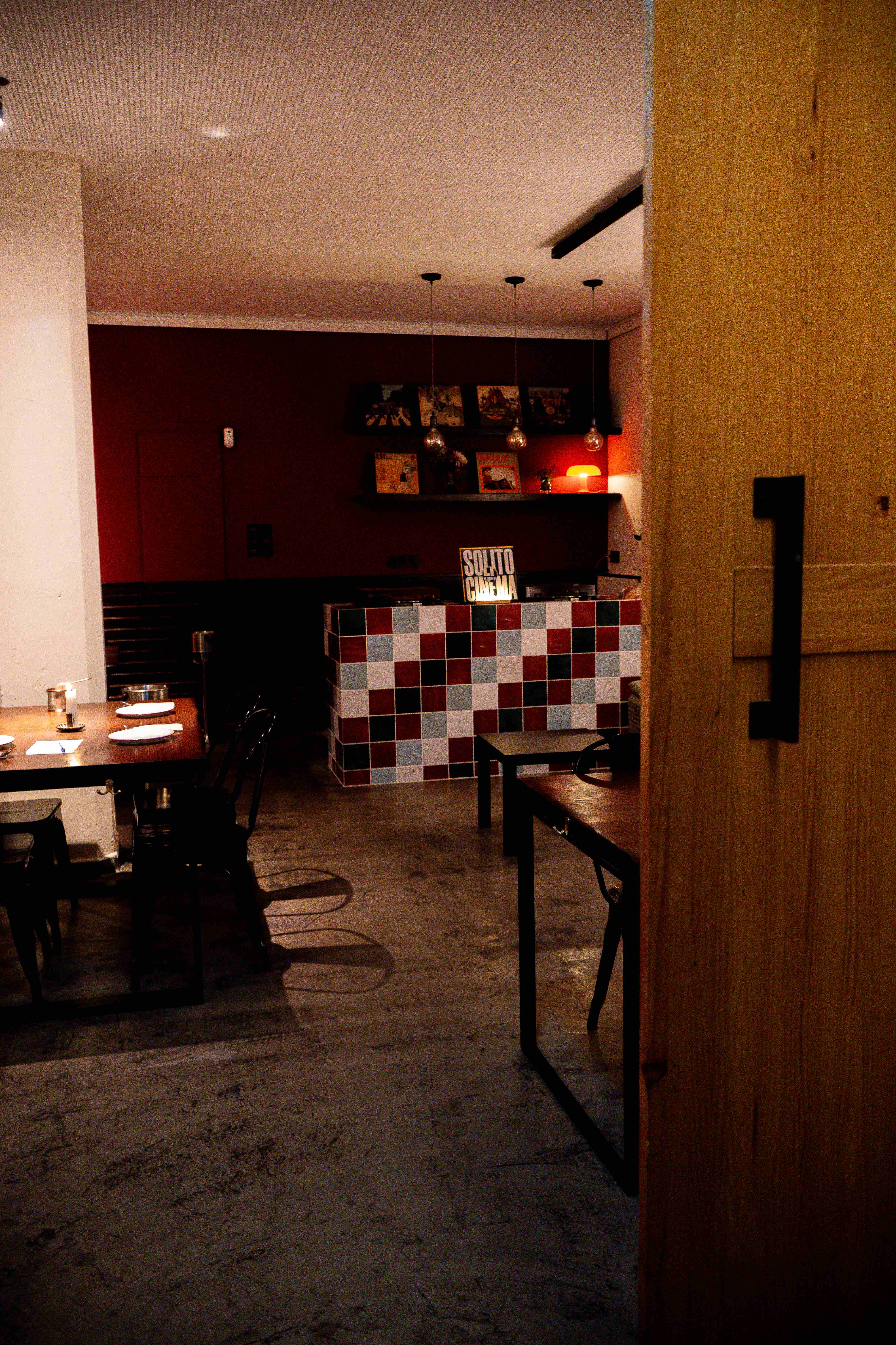 Interior de Oltre con vinilos y un mueble de azulejos de colores